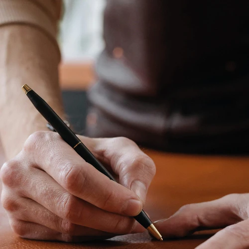 Penna promozionale personalizzata usata da un cliente in un ristorante, esempio di gadget personalizzati per locali.