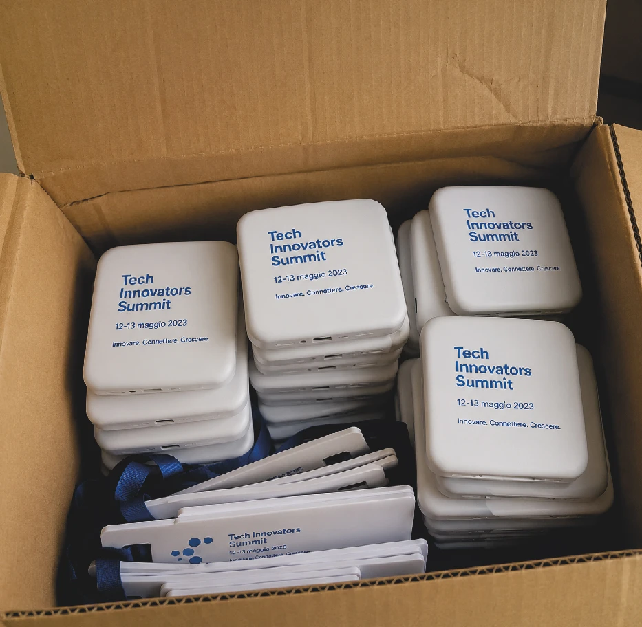 Gadget promozionali con nome dell'evento e data stampati rimasti invenduti dentro uno scatolone di magazzino
