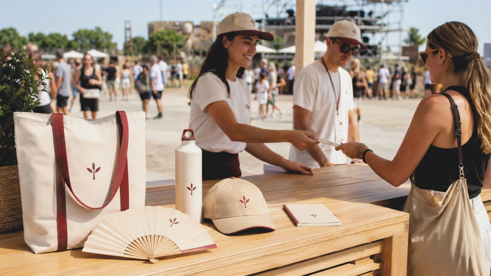Punto di distribuzione a un evento all'aperto con kit coordinato: shopper, borraccia, cappellino e ventaglio personalizzati